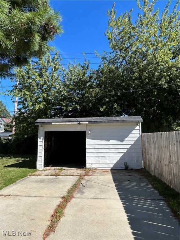 Garage featuring concrete driveway.