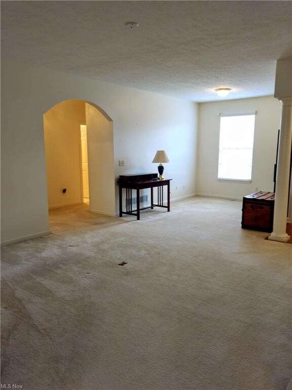 Living Room with arched doorway leading to bedroom