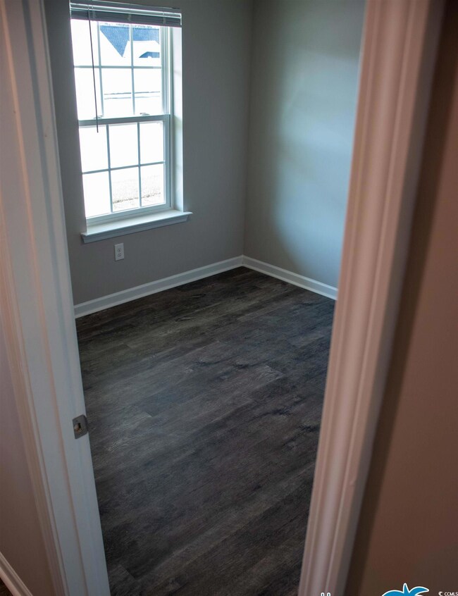 Unfurnished room with dark hardwood / wood-style f