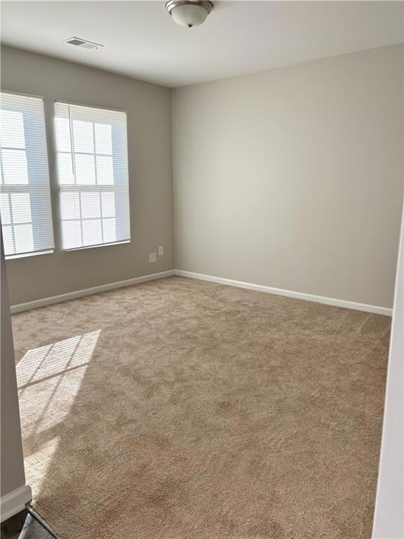 Carpeted empty room with baseboards