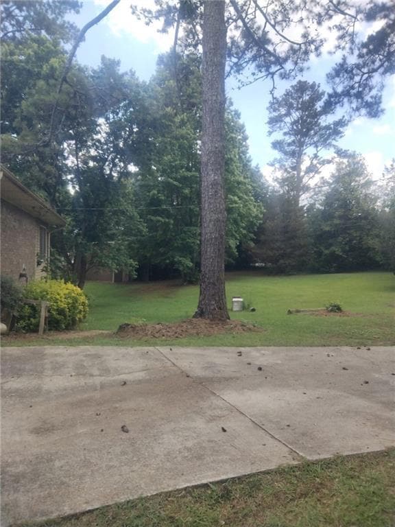 View of grassy yard featuring a patio area
