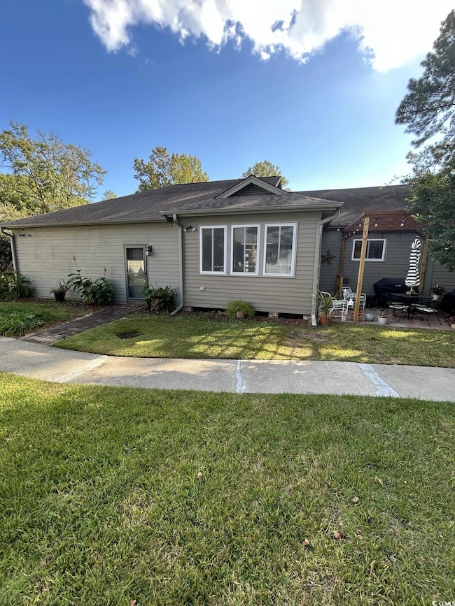 View of rear of home featuring a rear lawn and a patio area