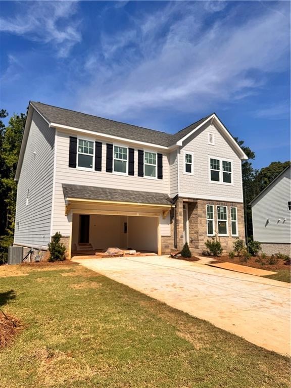 View of front of home with driveway, a front lawn, and stone siding