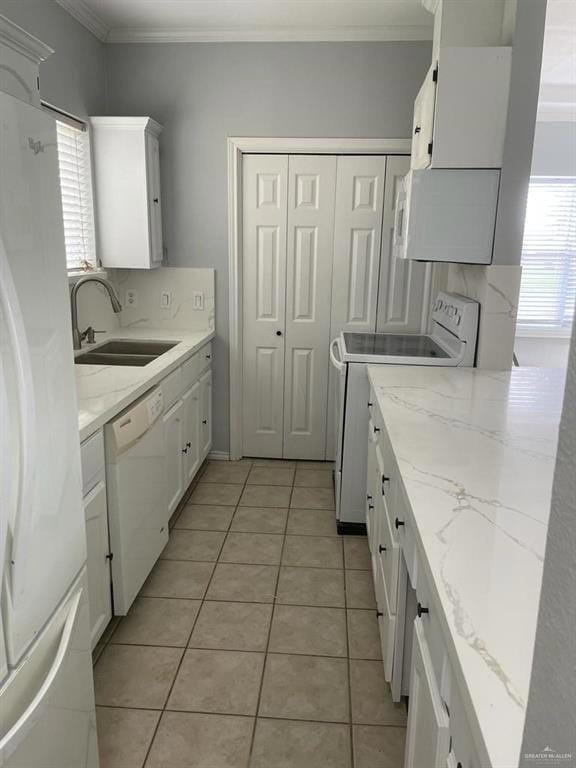 Kitchen featuring white cabinetry, white appliances, decorative backsplash, ornamental molding, and light stone countertops