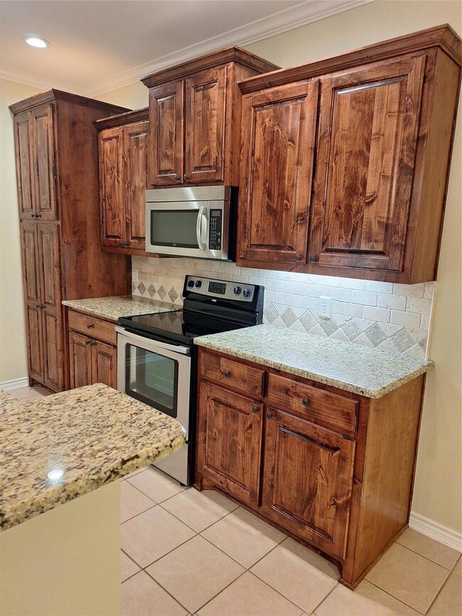 Kitchen with ornamental molding, backsplash, stain