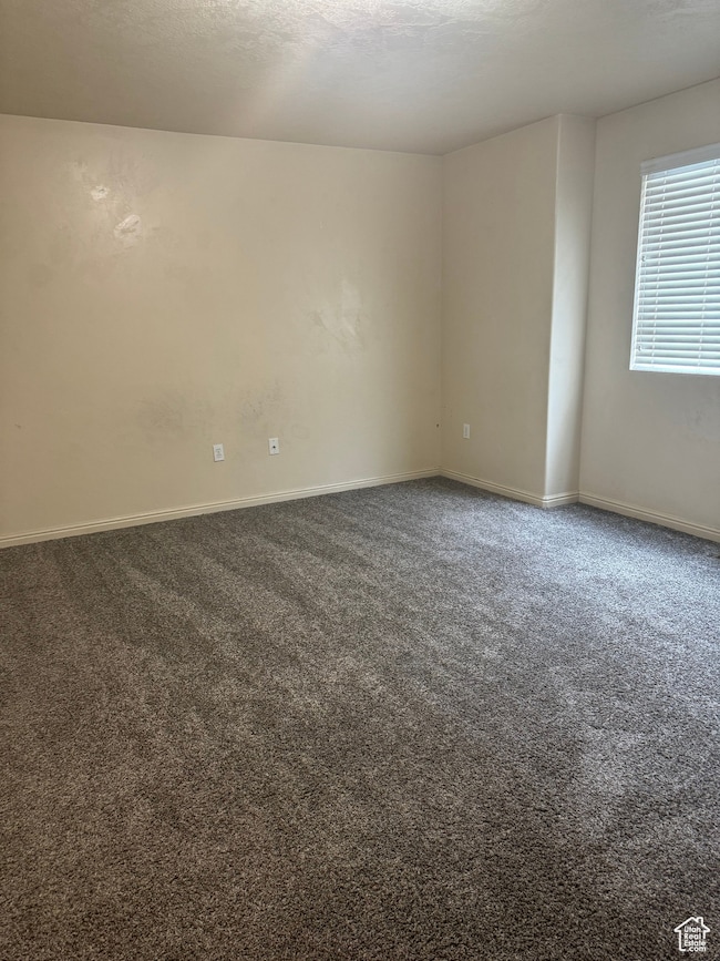 Unfurnished room featuring dark carpet