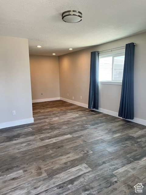 Empty room with recessed lighting, a textured ceiling, and wood finished floors