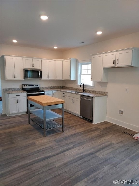 Kitchen with white cabinets, dark hardwood / wood-