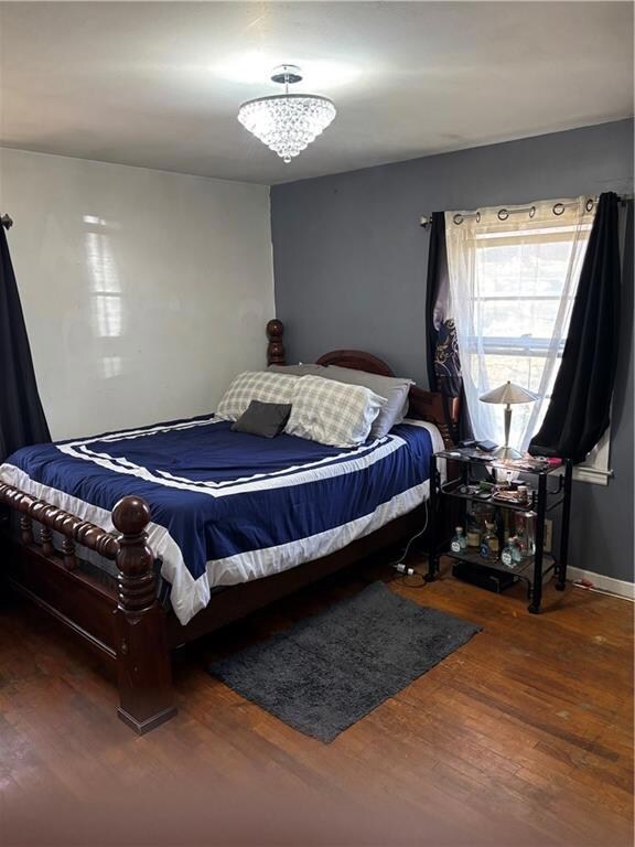 Bedroom with baseboards, wood-type flooring, and a