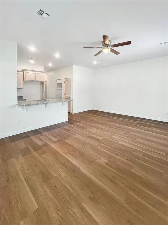 Living room featuring dark wood-style floors, a ceiling fan, and recessed lighting.Note: Photos are of a similar home by the builder.