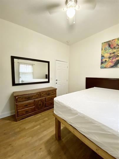 Bedroom with light wood-style floors and a ceiling fan