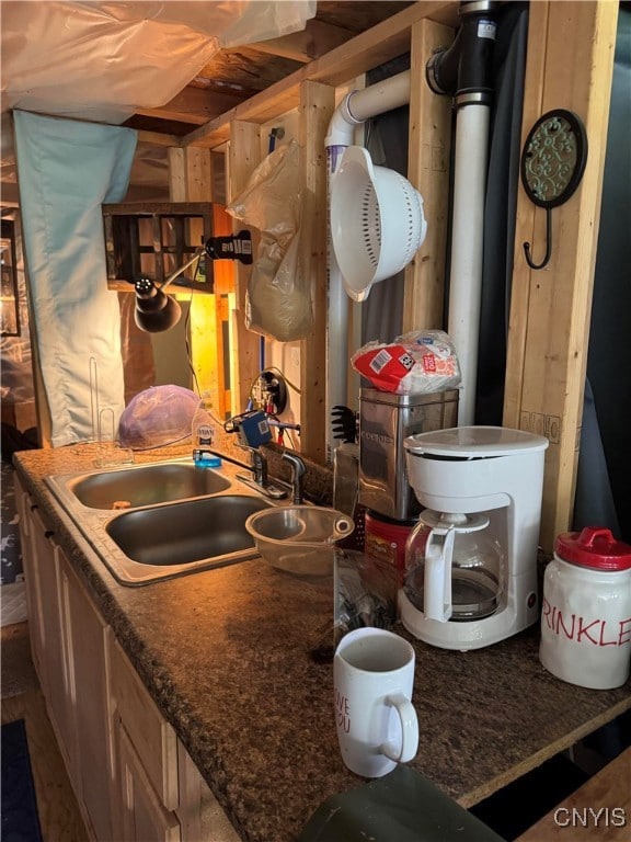 Kitchen area with double sink and cabinetry.