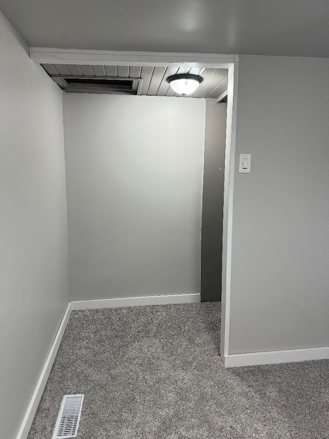 Carpeted empty room with baseboards