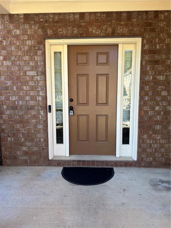 View of exterior entry featuring brick siding