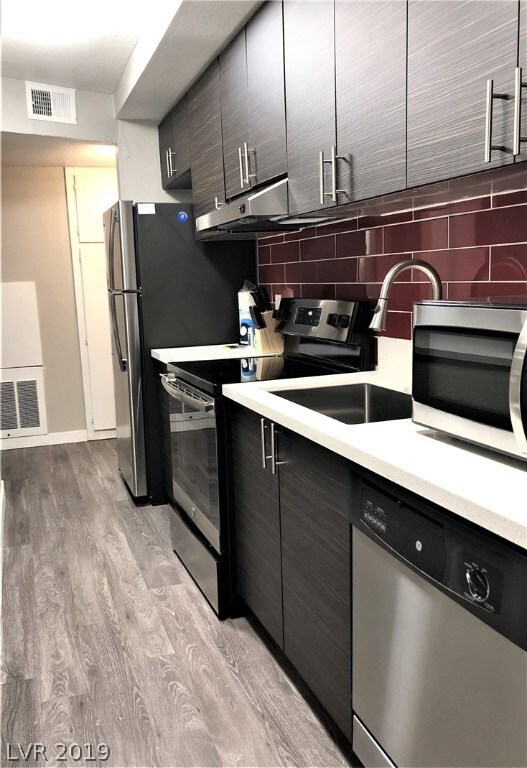 Well lit, galley style kitchen looks out into the living area.