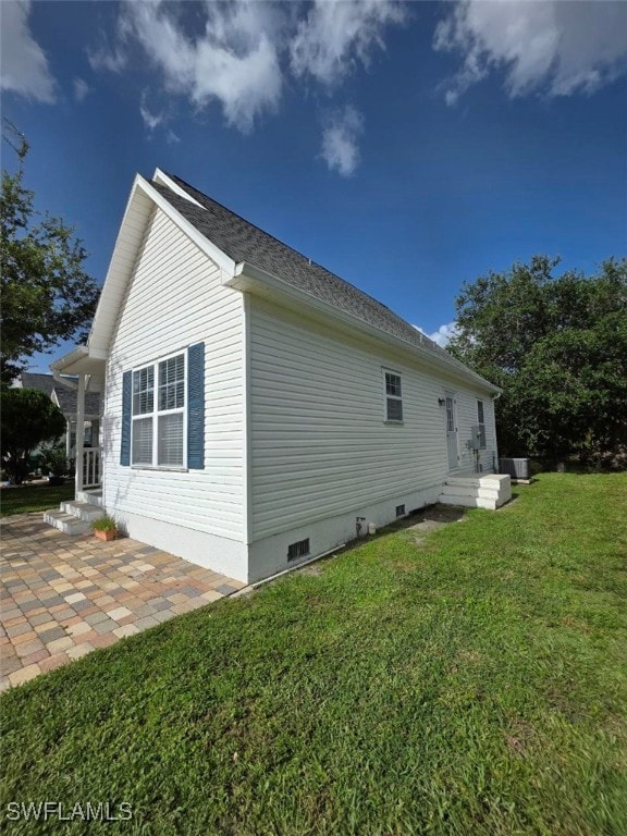 View of side of home featuring a lawn, a patio area, and crawl space