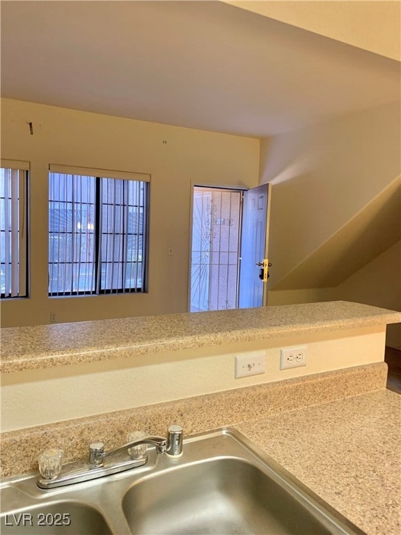 Kitchen view of a sink and light countertops