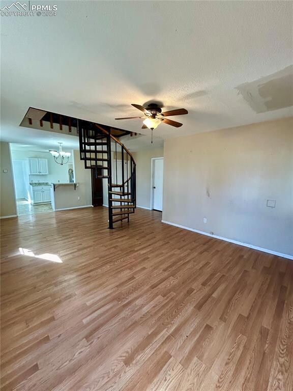 Spare room with ceiling fan with notable chandelie