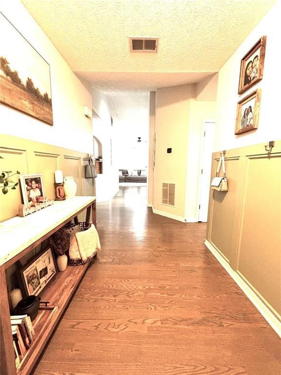Corridor featuring wood finished floors and a text