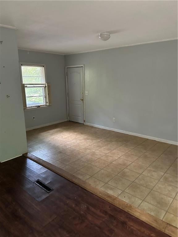 Unfurnished room featuring baseboards and crown mo