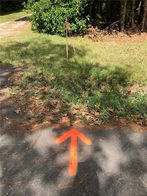 Left property line marked with stake and arrow pai