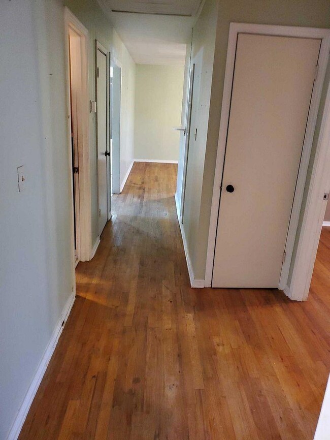 Corridor with baseboards and hardwood / wood-style