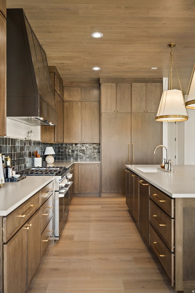 Kitchen with wooden ceiling, recessed lighting, premium range hood, stainless steel range, and light wood finished floors
