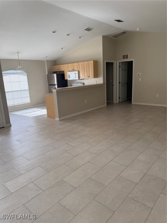 Kitchen featuring fridge, open floor plan, lofted