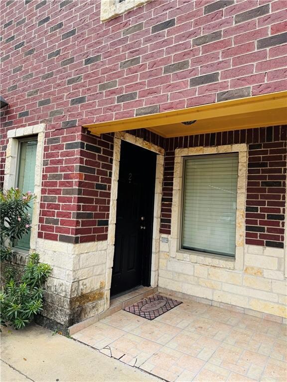 View of exterior entry with brick siding