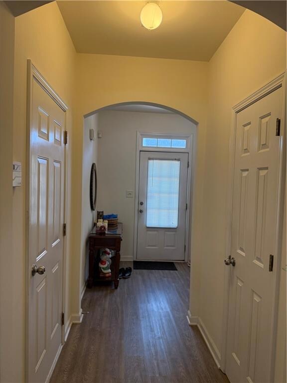 Foyer entrance with baseboards, arched walkways, a