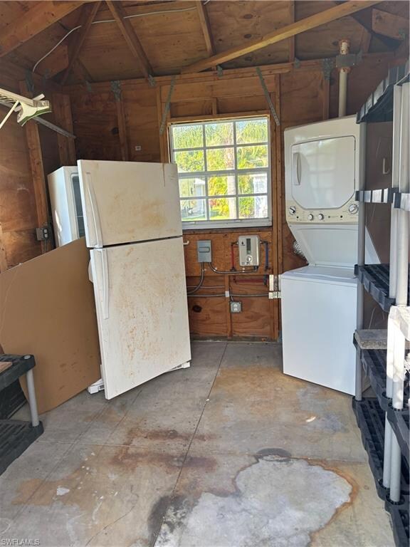 Laundry room with estacked washer and dryer and lofted ceiling
