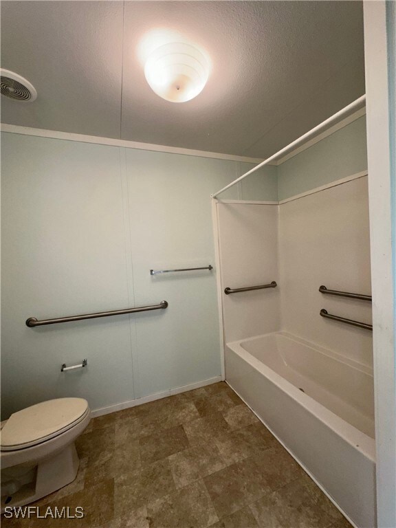 Bathroom featuring toilet, bathtub / shower combination, and tile patterned floors