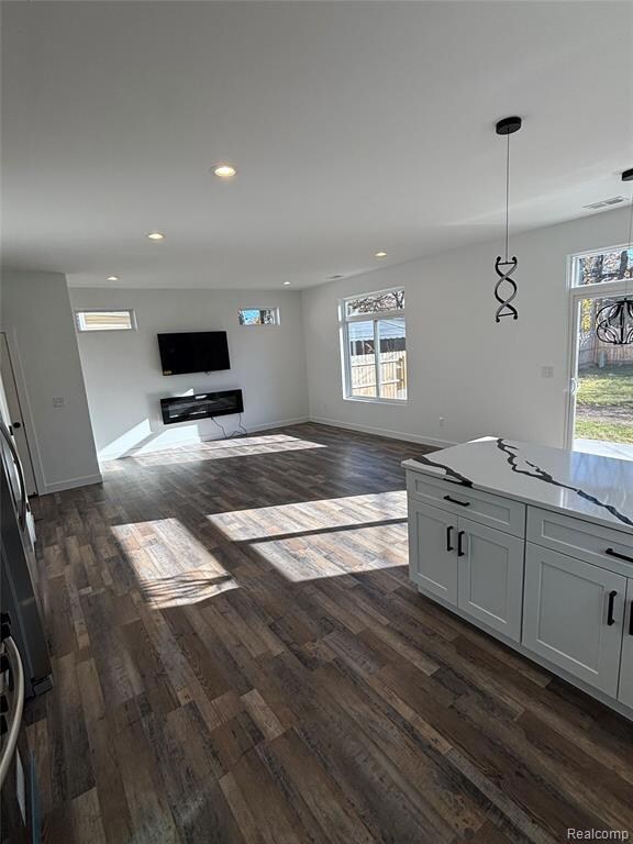 Unfurnished living room with dark wood-style floors and recessed lighting