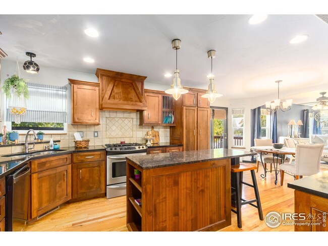 Custom kitchen with stellar wood cabinets, large island and a gas range.