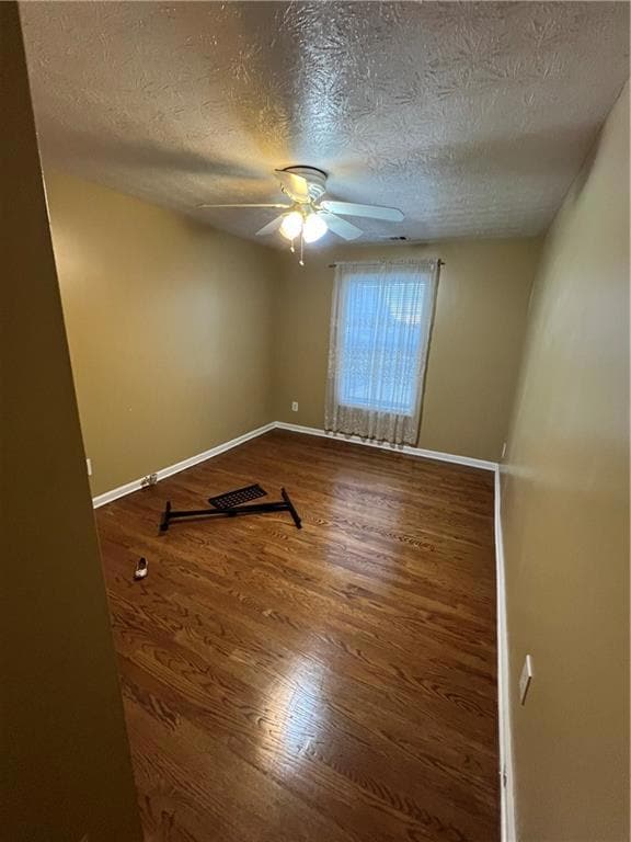 Spare room with a ceiling fan, wood finished floor
