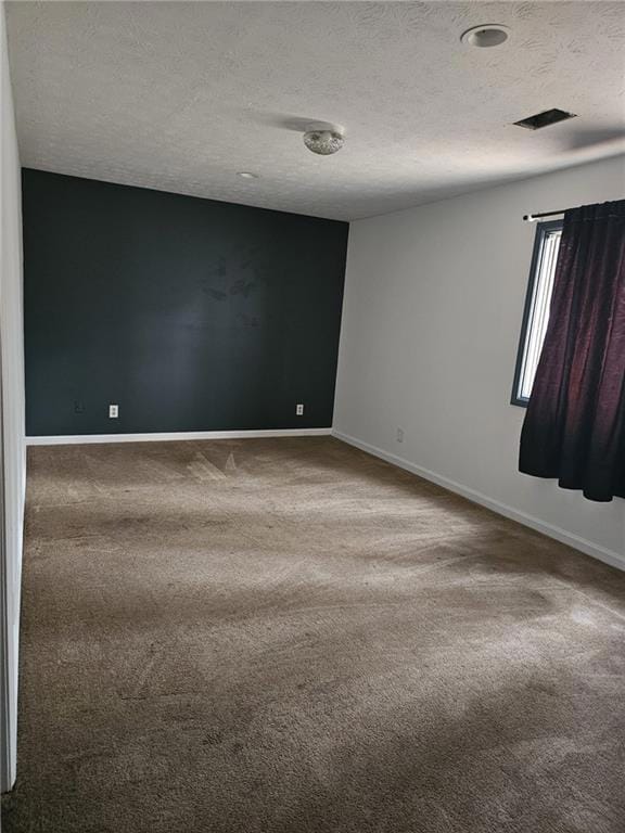 Carpeted spare room with a textured ceiling