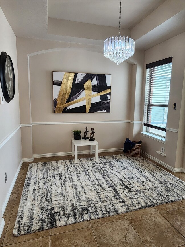 Dining space featuring a chandelier and a raised ceiling