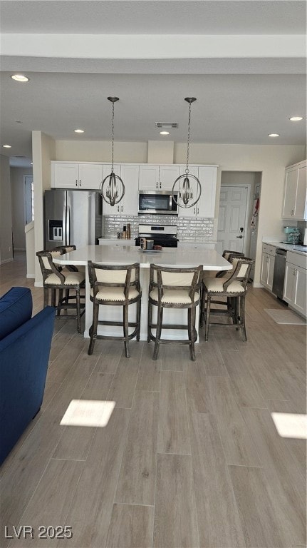 Kitchen featuring white cabinetry, light counterto