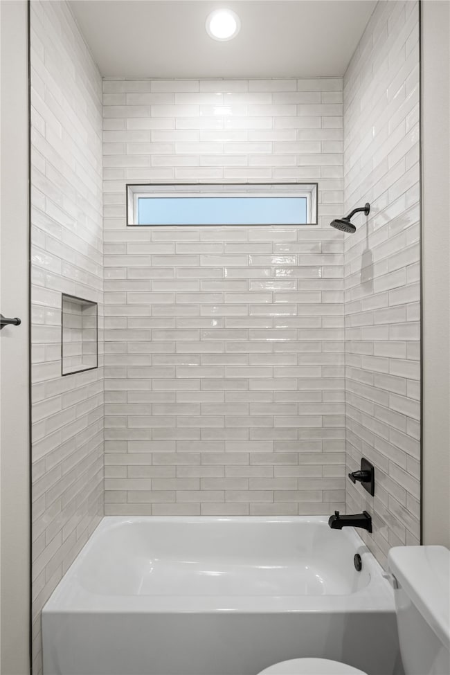 Full bath featuring  shower combination and healthy amount of natural light