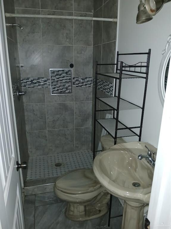 Bathroom with a shower stall and toilet