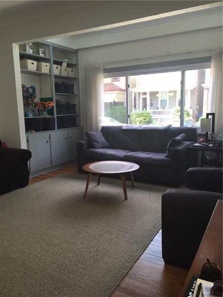 The spacious living room has built-in shelving and