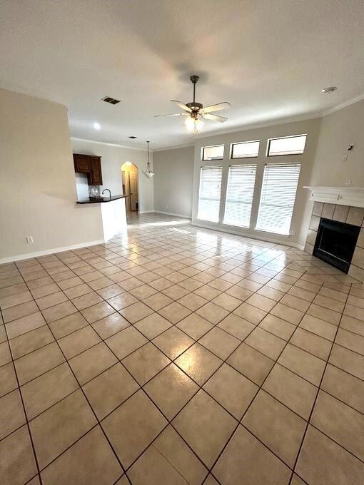 Unfurnished living room with ceiling fan, ornament