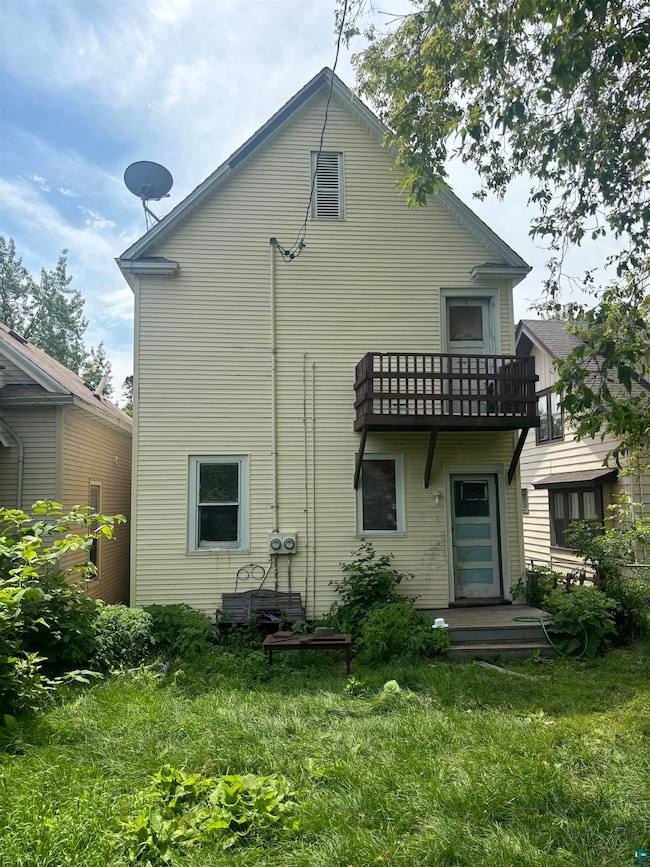 Rear view of house featuring a lawn