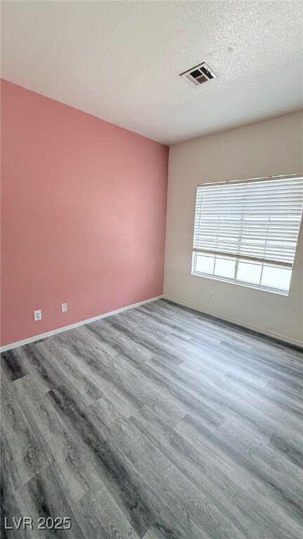 Empty room with baseboards, wood finished floors,