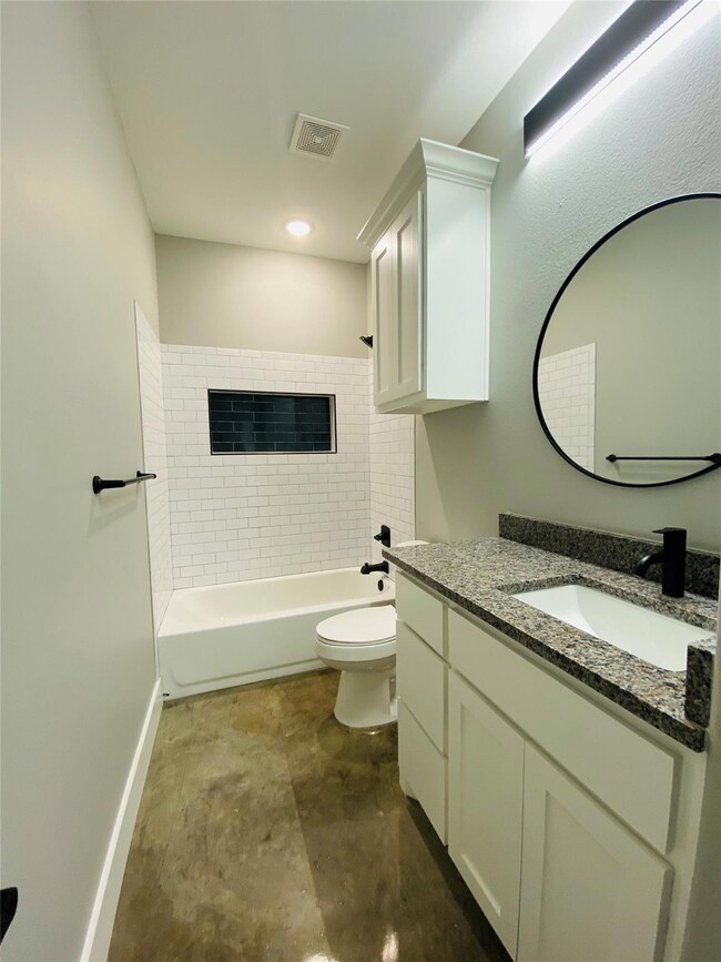 Full bathroom featuring concrete flooring, tiled s