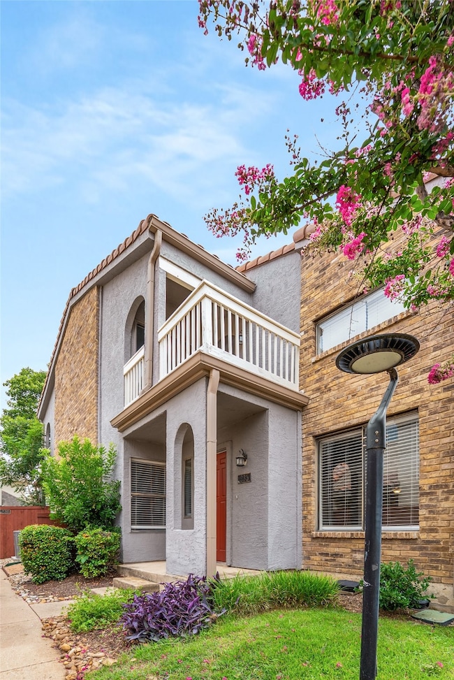 View of front of home featuring a balcony and stucco siding