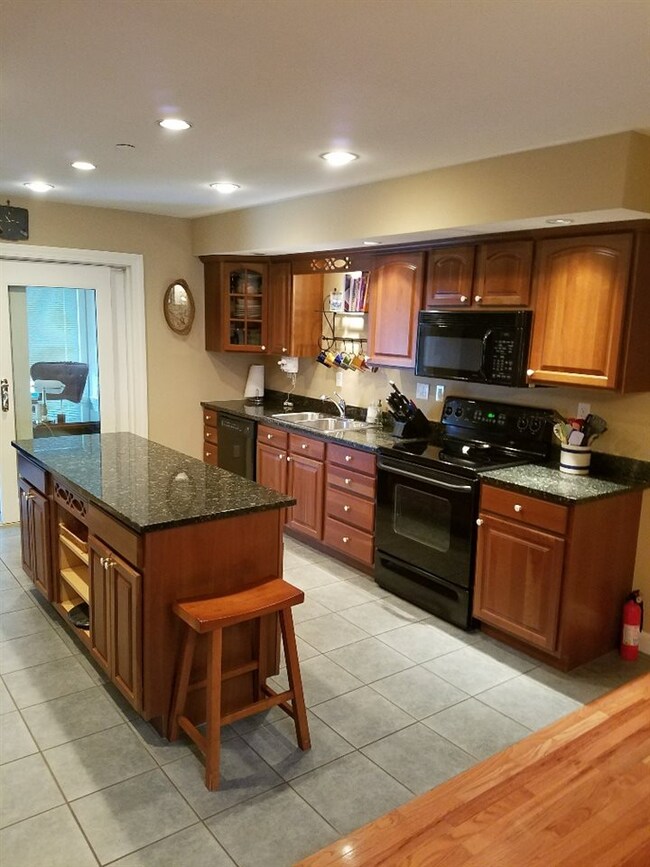 Cherry cabinets, black granite counters, center is