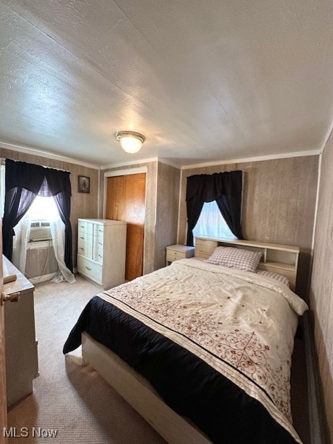 Bedroom with light carpet, multiple windows, and a textured ceiling