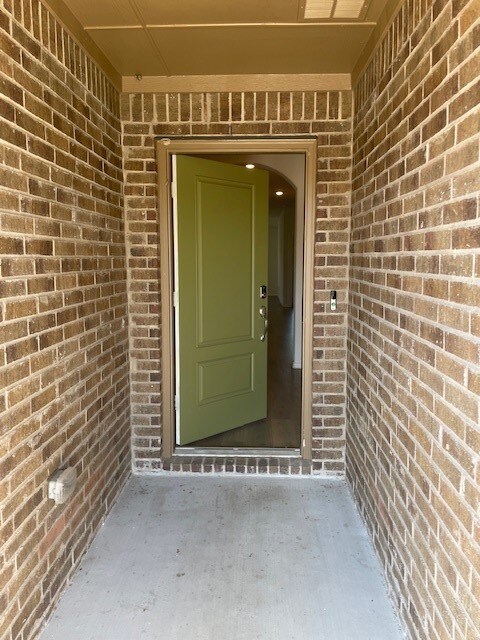 Property entrance featuring brick siding