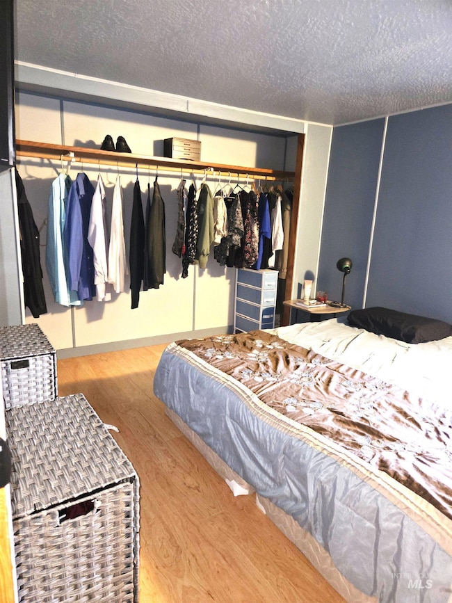 Bedroom featuring wood finished floors and a textured ceiling